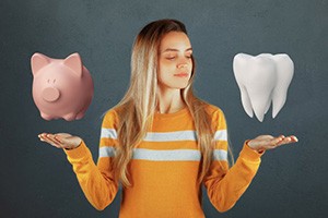 Woman comparing a piggy bank and digital image of a tooth