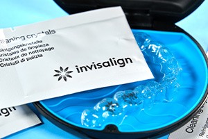 Patient in Amityville cleaning their Invisalign aligners