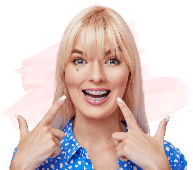 Woman with clear braces in Amityville pointing to her teeth