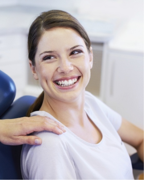 Woman in treatment chair smiling at her orthodontist