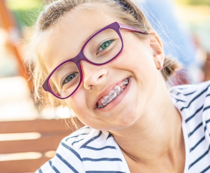 Young girl with glasses and braces smiling