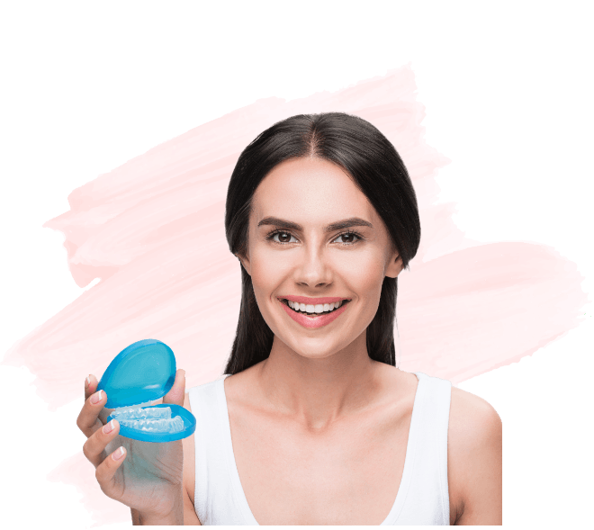 Smiling woman holding two Invisalign clear aligners in Amityville