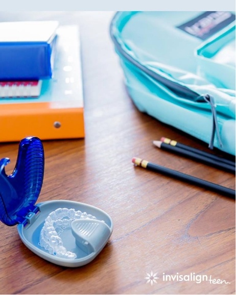 Invisalign aligner case on desk with school supplies