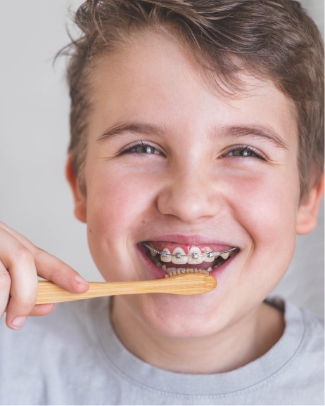 Boy with braces brushing his teeth